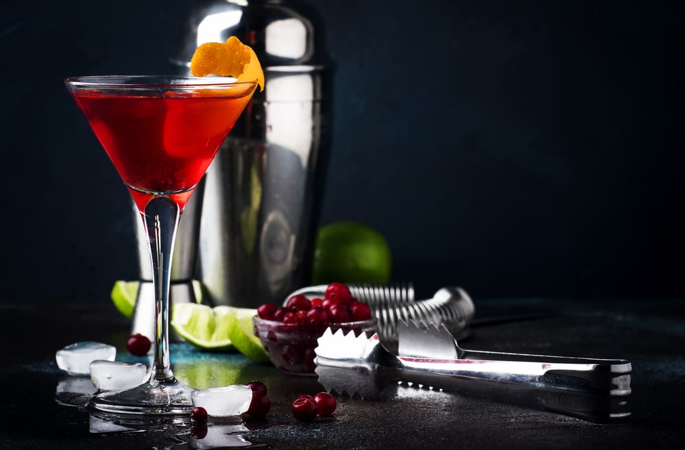 Classic alcoholic cocktail cosmopolitan with vodka, liqueur, cranberry juice, lime, ice and orange zest, 