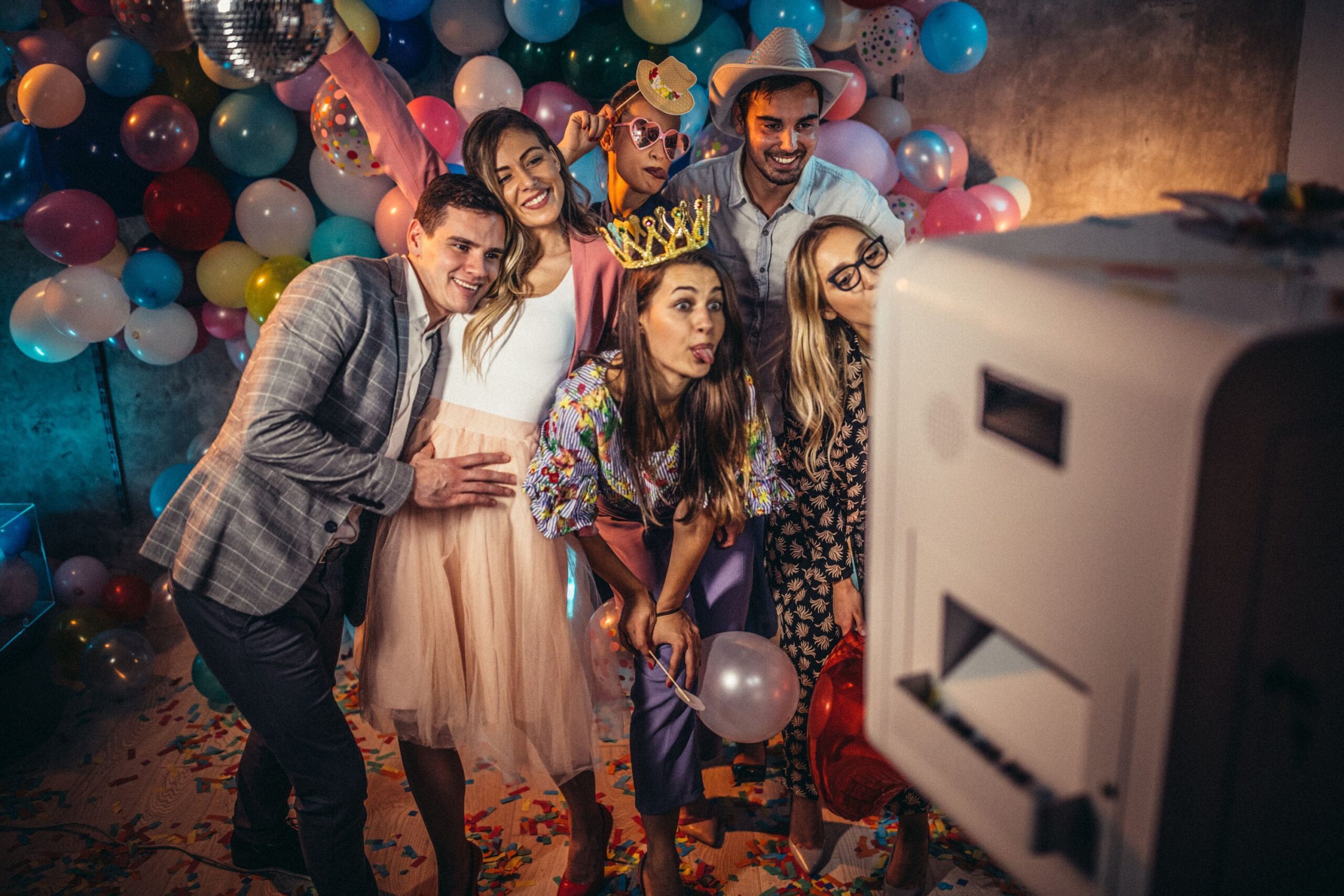 People posing in a photo booth at a surprise party.