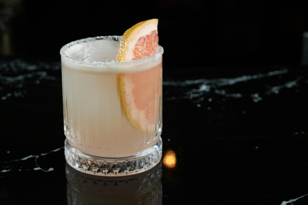 Refreshing Paloma cocktail in a tall glass with grapefruit slice and salted rim